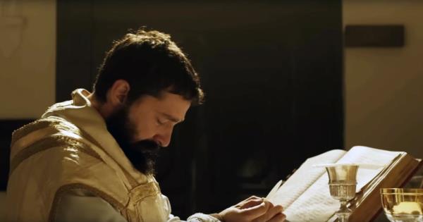 Shia LaBeouf as Padre Pio kneels and prays.