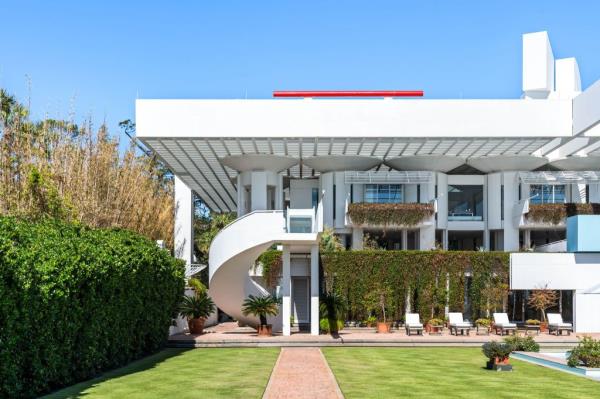 The design is prominently accented with a grid-like canopy and massive columns.