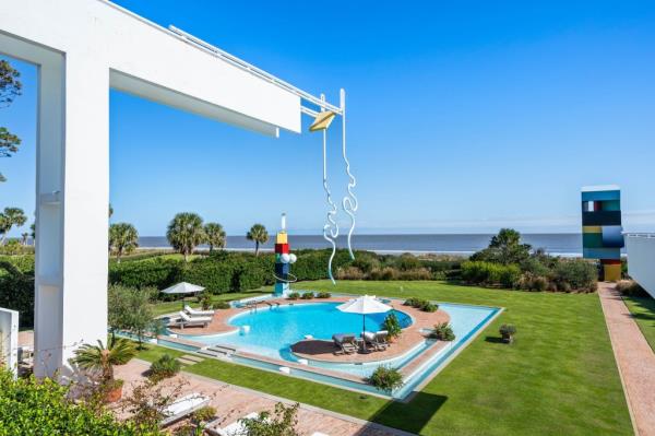 The pool, surrounded by vibrant sculptures, faces the ocean.