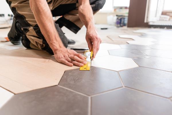 Professio<em></em>nal man installing tile on the floor