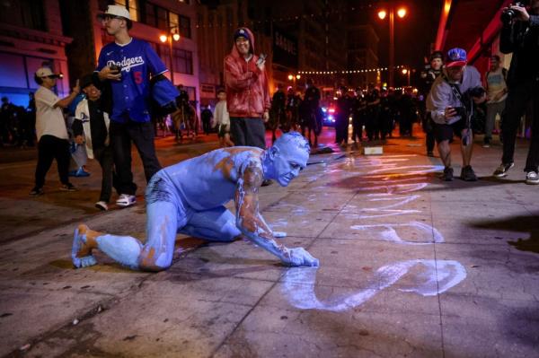 The man was covered in blue paint -- and wearing little else -- as he scrawled a victory message across the sidewalk