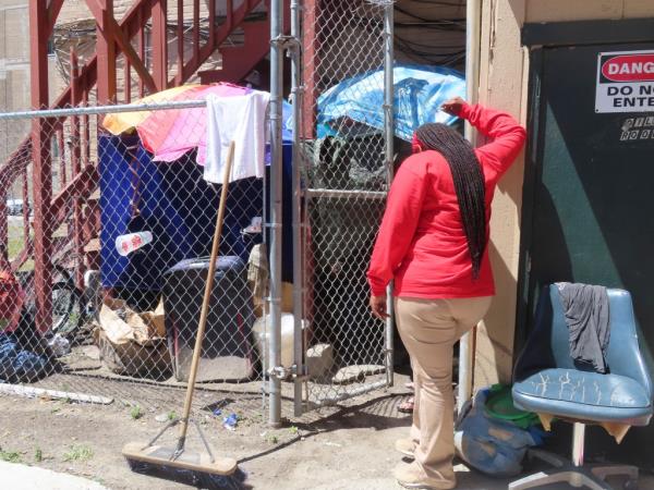 An outreach worker talks to a homeless woman ensco<em></em>nced in a makeshift shelter she erected behind an apartment in Atlantic City, N.J., on Monday, July 1, 2024. The city is launching programs to address homelessness in the seaside gambling resort. (AP Photo/Wayne Parry)