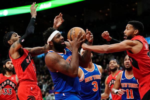 Knicks center Mitchell Robinson, center, is fouled by Toro<em></em>nto Raptors forward Garrett Temple