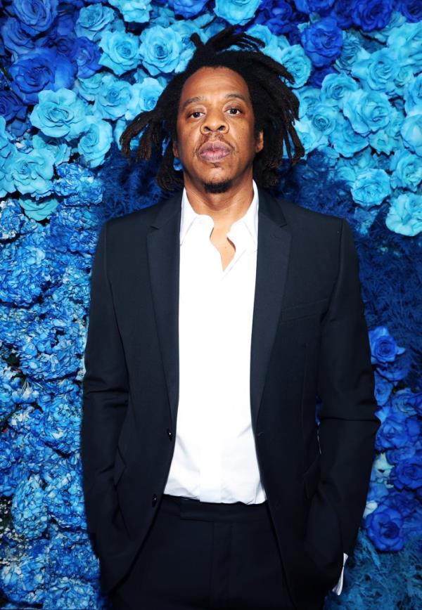 Jay Z in front of blue flowers. 