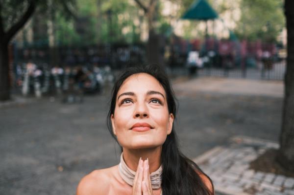 Close up Gabriella Mordocea outside park with prayer hands.