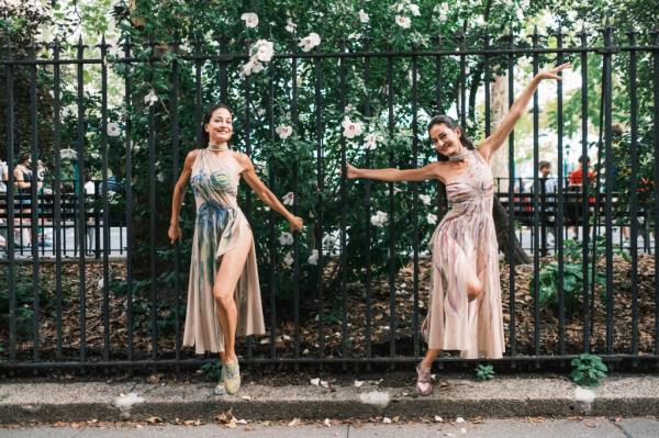 Twins Gabriela Mordocea and Mihaela Mordocea dancing in John Jay park with a black fence as backdrop. 