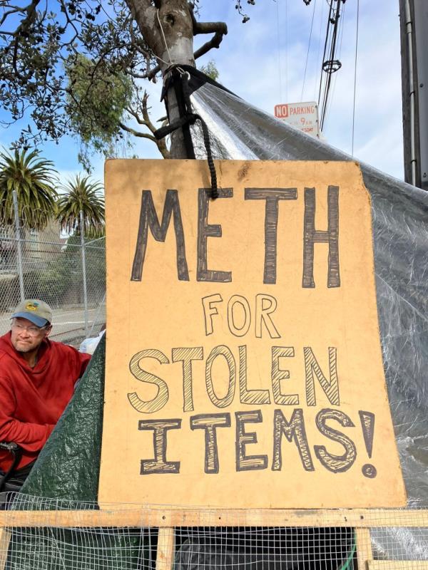 Moore is pictured sitting outside his tent, with the 