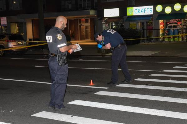 Police seen examining evidence at the scene of the shooting 