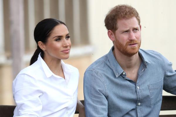 Prince Harry and Meghan, Duke and Duchess of Sussex, sitting on a bench with a local farming family in Dubbo, Australia during their Autumn tour
