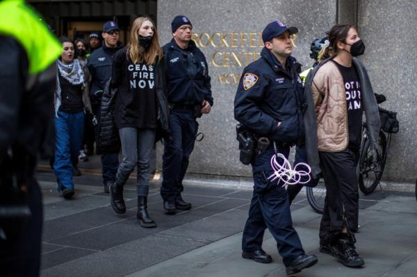 Hunter Schafer is escorted out of 30 Rock by an NYPD officer with her hands restrained behind her back on Feb. 26.