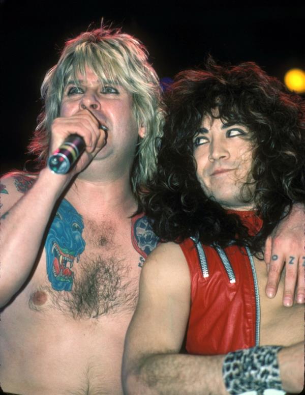 Ozzy Osbourne with tattoos singing into a microphone alo<em></em>ngside long-haired Jake E. Lee in Los Angeles, California