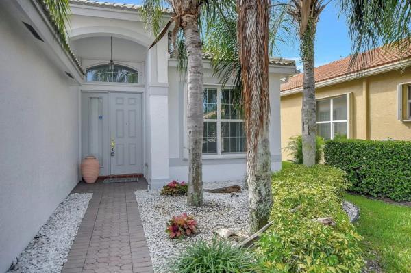 the white entry way to the pollacks new hoome with palm trees in front