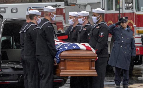 A group of men wearing masks carrying the coffin of Kyle Mullen at his military funeral at St. Thomas More Roman Catholic Church in Manalapan