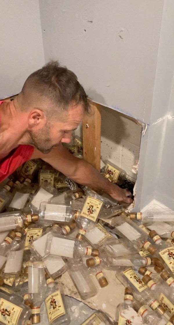 Roy scooping out more bottles from the wall