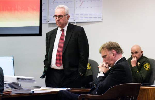 Attorney Jack Earley, standing, and his client Eric Scott Sills listen to Sills 911 call from the day of his wifes death during  opening statements in Orange County Superior Court in Santa Ana, CA on Tuesday, November 28, 2023