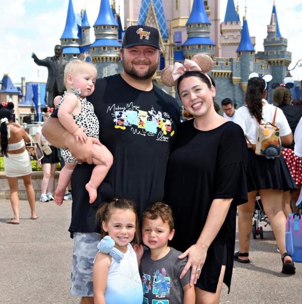 Haley Sisk, Austin and their three children Everly, Ryder, and Ella in front of Cinderella's Castle at Disney World, Orlando, Florida