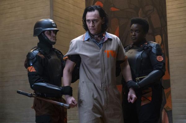 Tom Hiddleston being restrained by guards. 