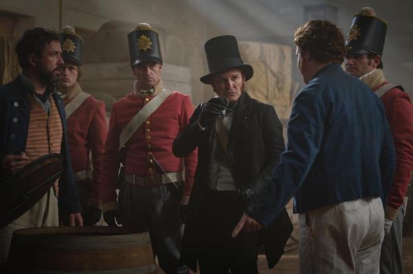 Damon Herriman as Captian Gaines, with a top hat looking serious. 