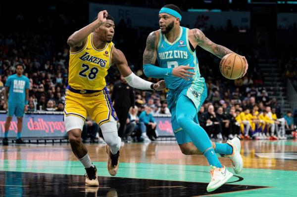 Charlotte Hornets forward Miles Bridges (0) drives to the basket while guarded by Los Angeles Lakers forward Rui Hachimura (28) during an NBA basketball game.