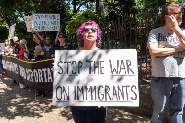 A counter-protestors holds a sign demanding that the other side 
