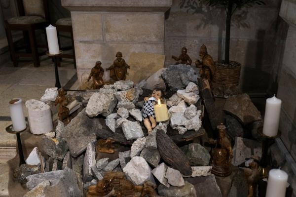 An installation of a scene of the Nativity of Christ with a figure symbolizing baby Jesus lying amid the rubble, in reference to Gaza.