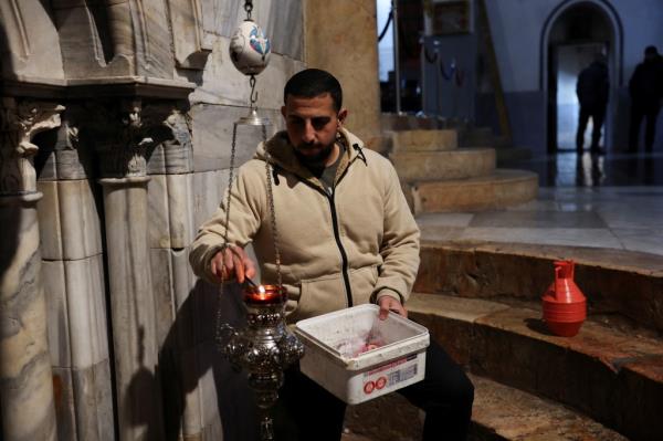 A Palestinian man changes candles in the Church of the Nativity on Dec. 23.