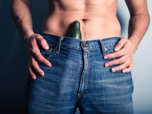 A young man with a cucumber stuffed down his pants