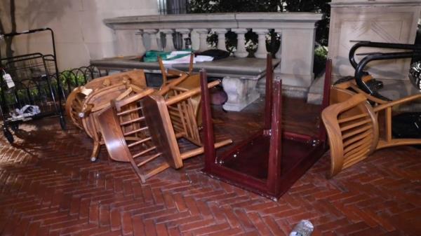 Aftermath of occupation of Columbia University's Hamilton Hall, with a pile of chairs on a brick floor