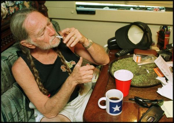 Willie Nelson smoking with a plate of pot in front of him. 