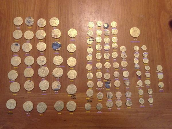 A group of centuries-old gold coins recovered by Florida authorities, originally from the 1715 Treasure Fleet, displayed on a table.