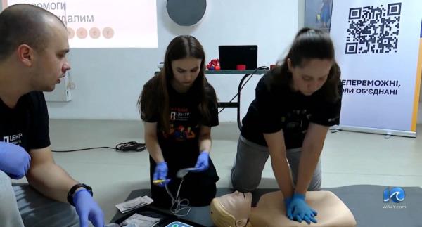 Girls doing chest compressions on a dummy