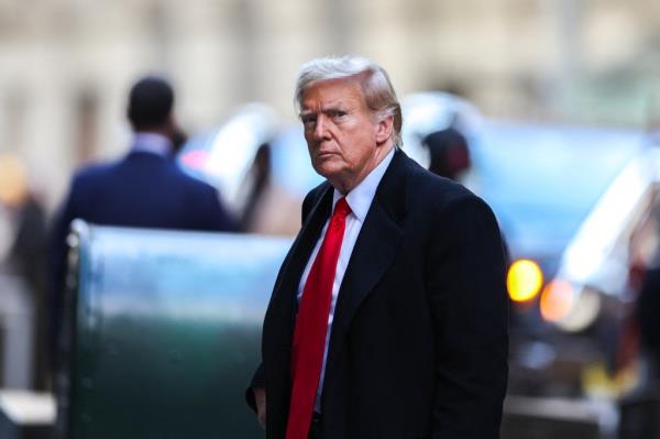 Former US President Do<em></em>nald Trump, in a suit and tie, arriving at 40 Wall Street in New York City for a court hearing regarding his civil fraud case.