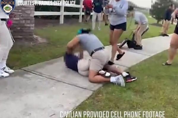 The juvenile in grey is seen on top of the other girl laying down a string of punches.