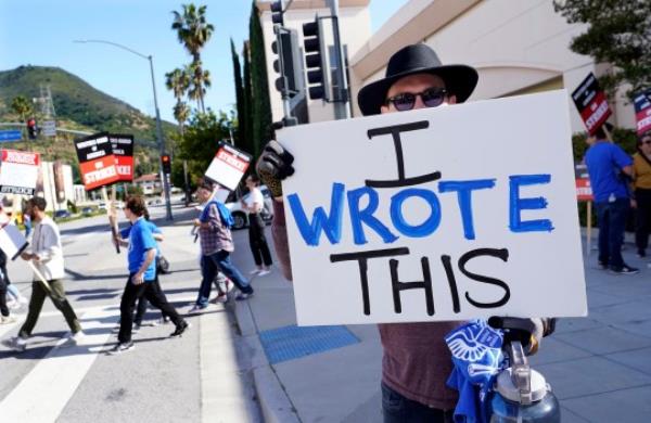 Justice Hardy holds up a sign during the WGA writer strike