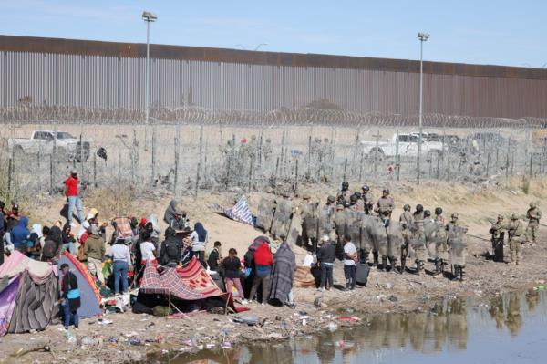 Texas Natio<em></em>nal Guard troops stand off with migrants at the border in El Paso