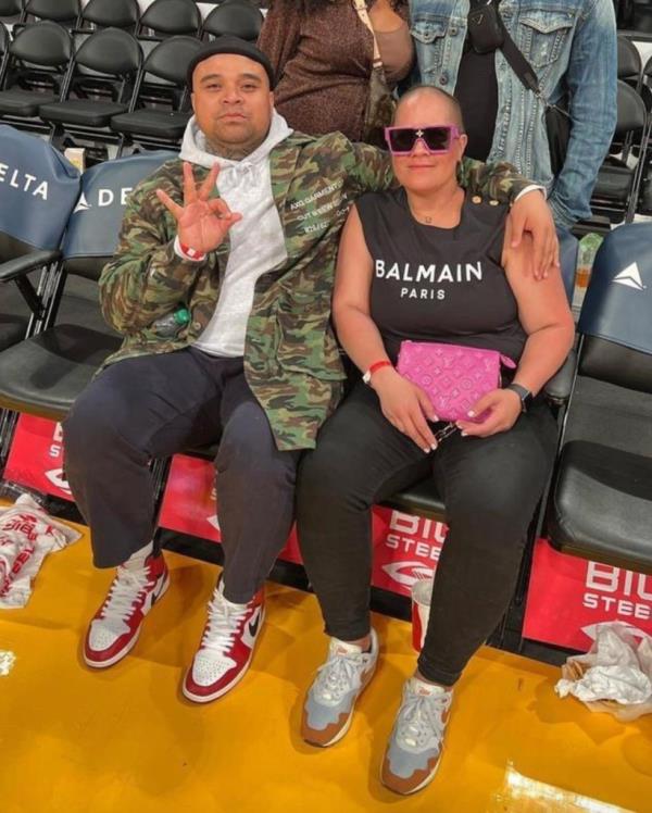 Adelle Fo<em></em>nofale Levi, pictured holding a pink Louis Vuitton clutch and wearing a designer Balmain top, and Poutasi Brown while sitting courtside at a Lakers game in March 2022.