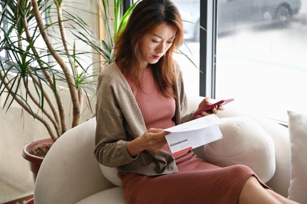 Woman checking her bank statements on a sofa