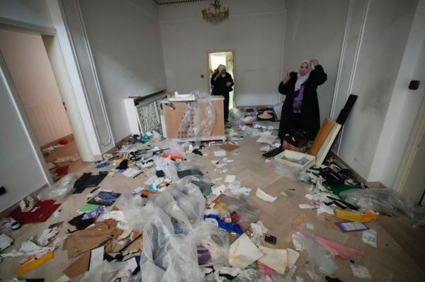 A woman looks at a ransacked room at the private residence of Syrian President Bashar Assad in the Malkeh district of Damascus, Syria, on Sunday, Dec. 8, 2024.