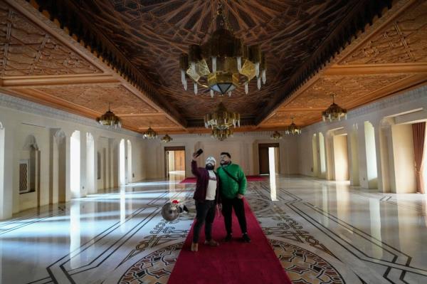 Two men use their cell pho<em></em>nes while walking through the halls of Syrian President Bashar Assad's presidential palace. 