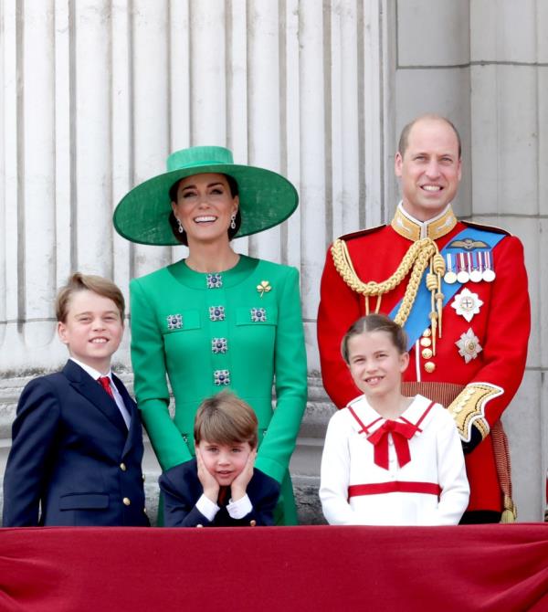 Kate Middleton with her kids and Prince William smiling. 