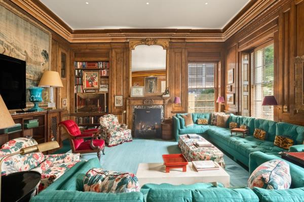 Interior 146 East 65th Street, with emerald couches and wood walls. 