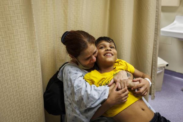 Esperanza embraces her son Pedro while she waits to be treated at Stroger Hospital.
