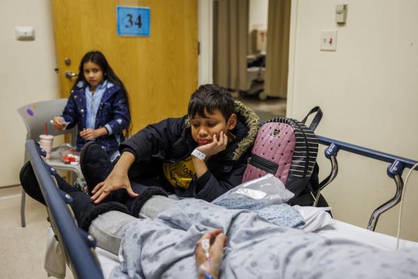 Yuledy and her brother Pedro with their mother while she waits to get a CT scan at Stroger Hospital.