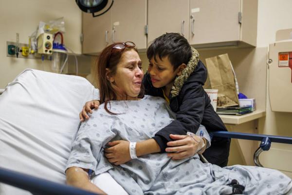 Pedro hugs his mother after a doctor explained the results of the CT scan showed black spots in the pockets of fat on her neck. The doctor said a biopsy would be needed to see if the spots were cancerous.