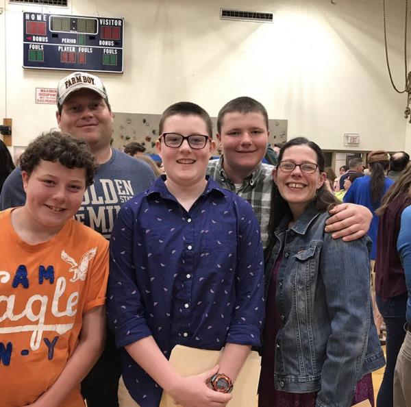 A mother wipes a tear from her face as she holds a photograph of her deceased son Nate.