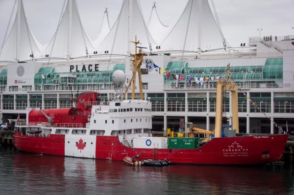 Polar Prince ship painted red with Canadian flag at a dock. 