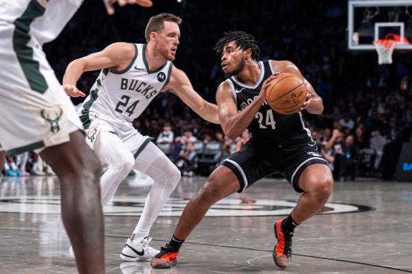 Cam Thomas looks to make a move on Pat Co<em></em>nnaughton during the Nets' loss to the Bucks.