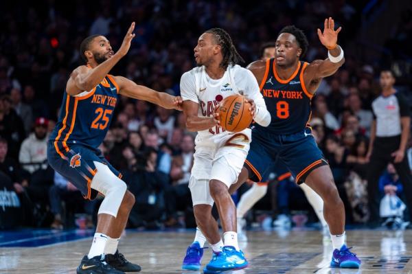 New York Knicks forward Mikal Bridges (25) and  forward OG Anunoby (8) defend Cleveland Cavaliers guard Darius Garland (10) during the second half at Madison Square Garden, Monday, Oct. 28, 2024, in New York, NY. 
