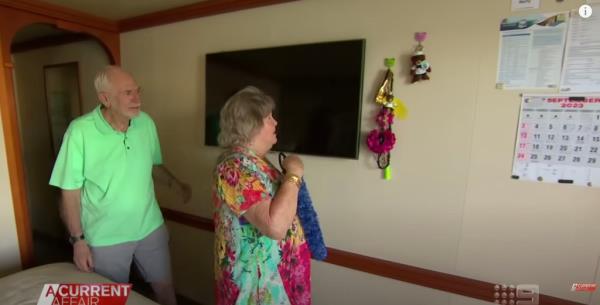 Marty and Jess Ansen hang a decoration on the wall of their cabin on board the Coral Princess cruise ship.