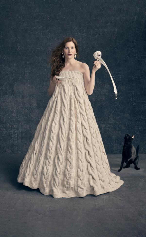 Kathryn Hahn in knit gown pouring milk to a cat